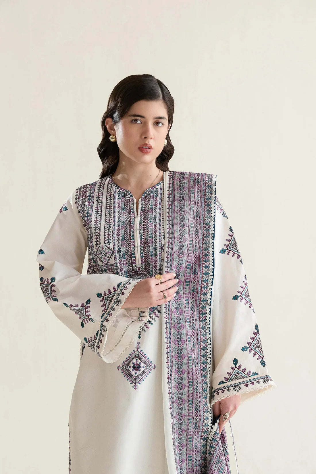 Ivory Dhanak dress close-up showing mauve and teal geometric embroidery on the shirt and dupatta