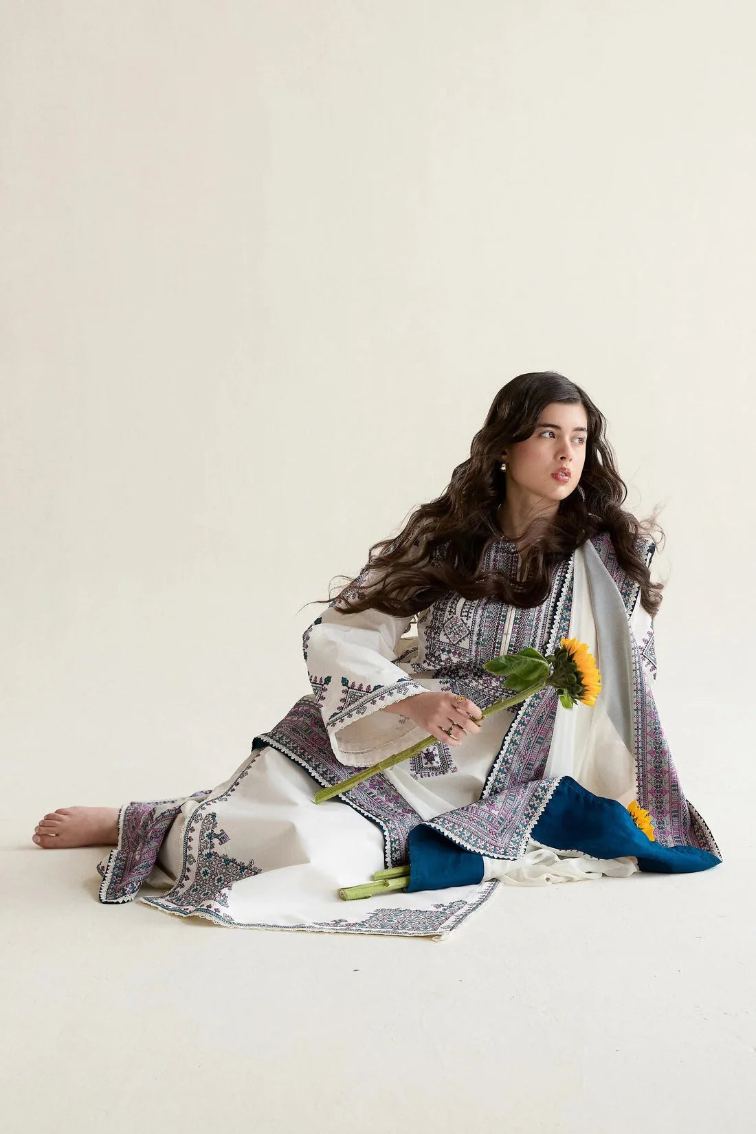 Ivory Dhanak 3-piece dress seated styling view showing the embroidered hem and dupatta border