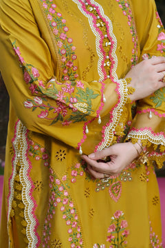 Close-up of mustard Dhanak dress sleeve with pink floral embroidery and white decorative trim