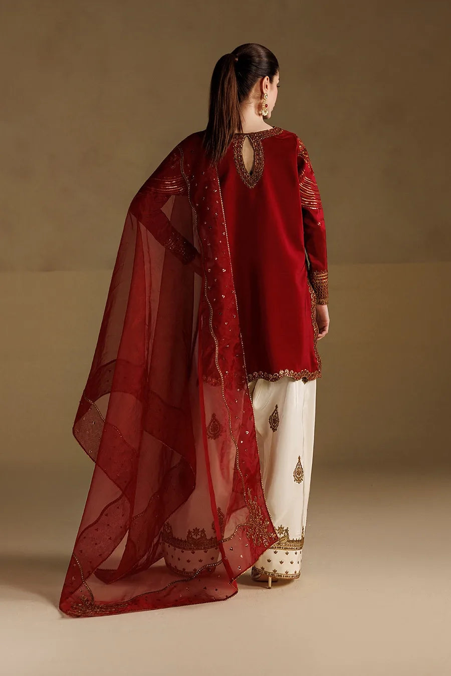 Back styling view of red Dhanak dress with gold embroidery, red dupatta and ivory trousers