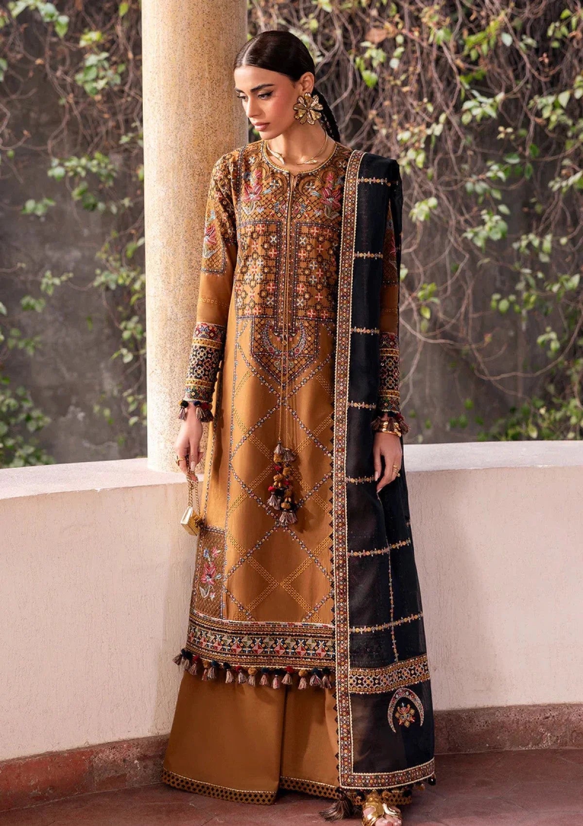 Mustard Dhanak unstitched 3-piece dress showing multicolour embroidery and black Pashmina shawl, angled view